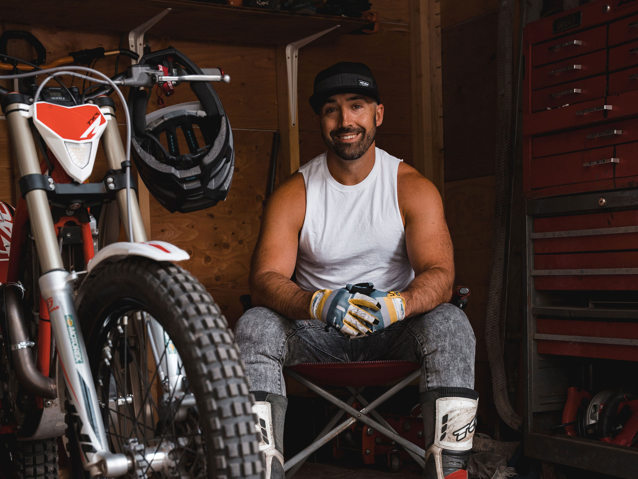 Cody McNolty sitting in his garage by his motorcycle