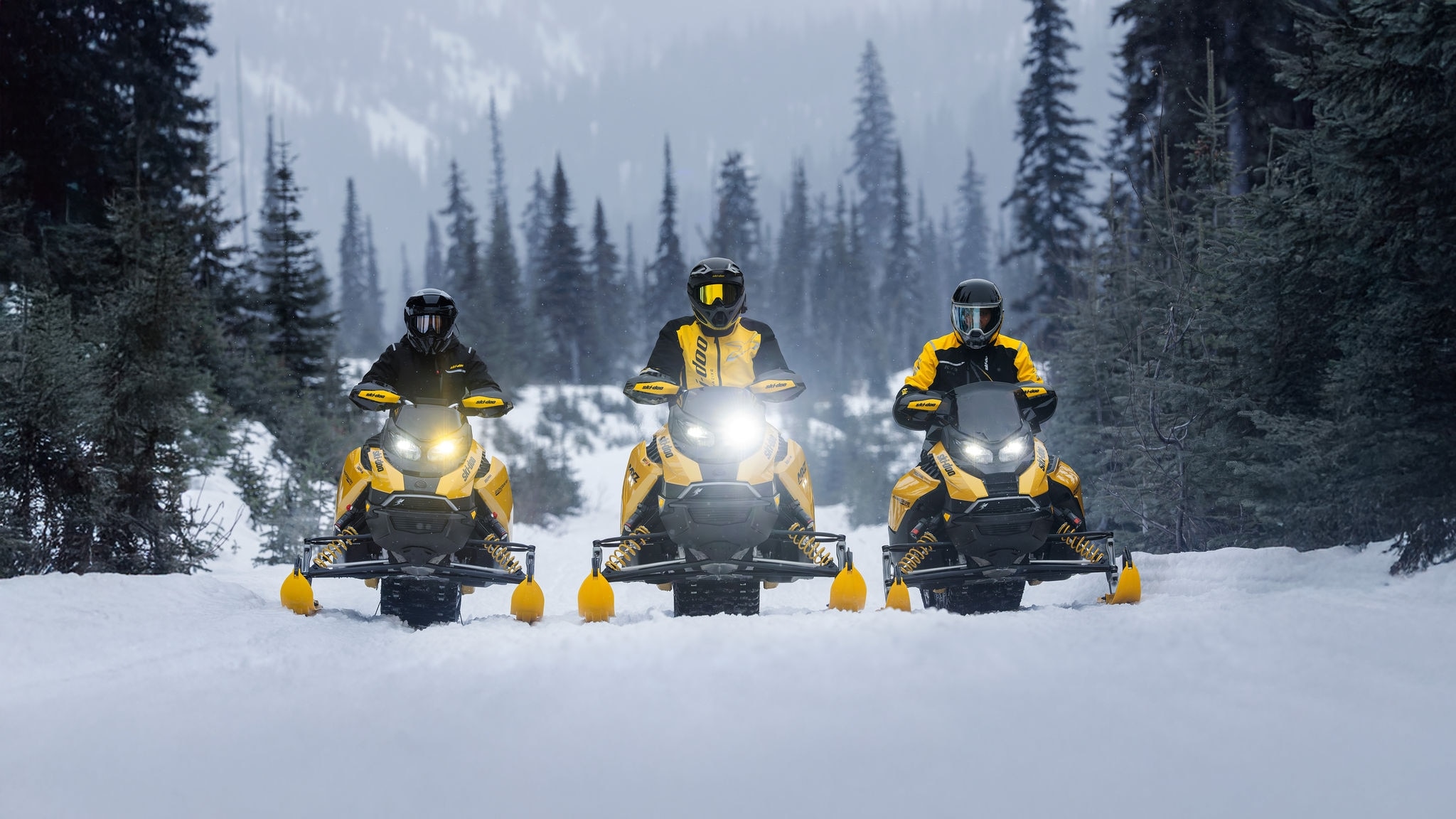 Tre 2027 Ski-Doo X-RS-snöskotrar stillastående på leden sida vid sida.