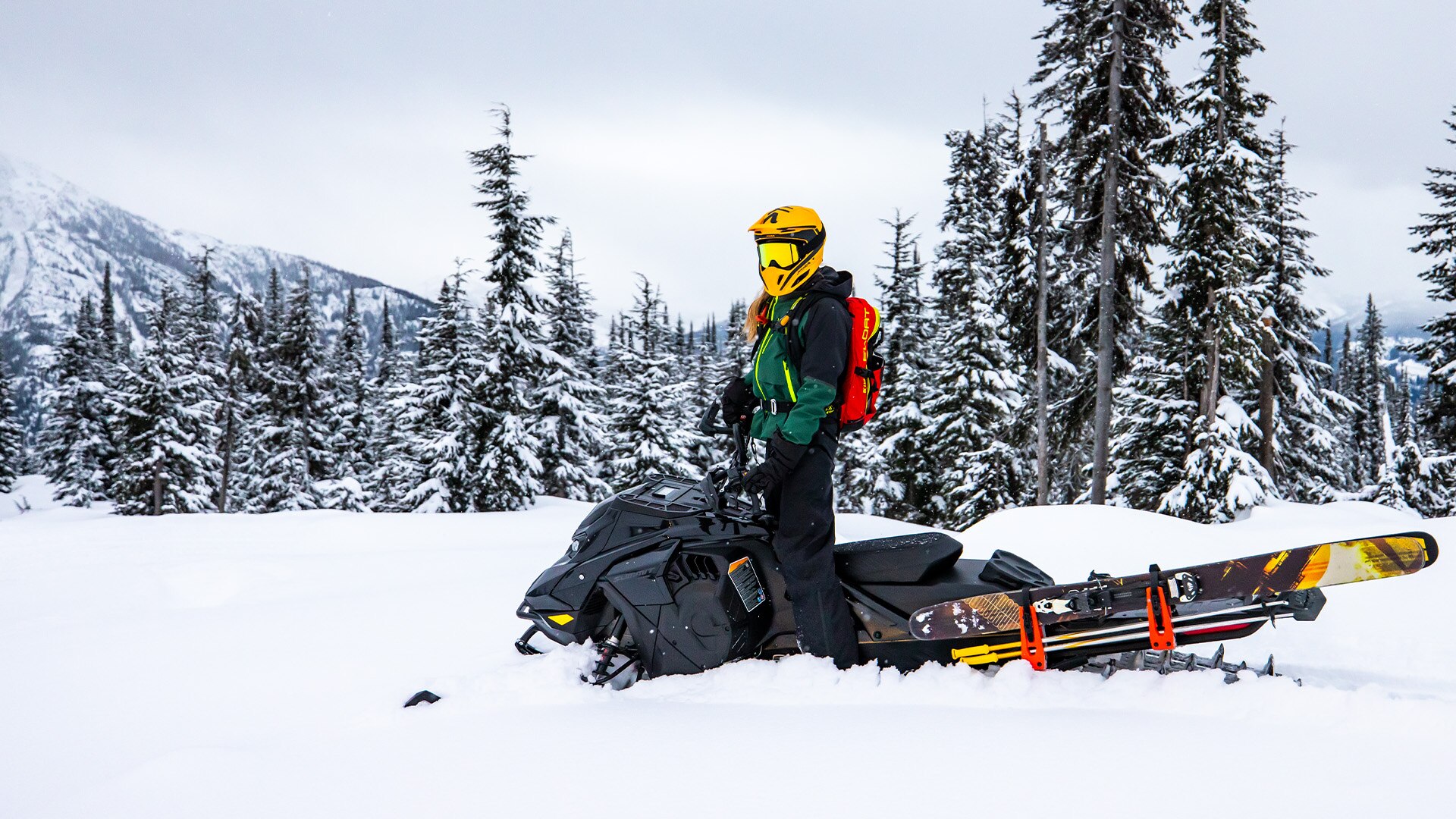 Rider standing up on this Ski-Doo snowmobile in deep snow