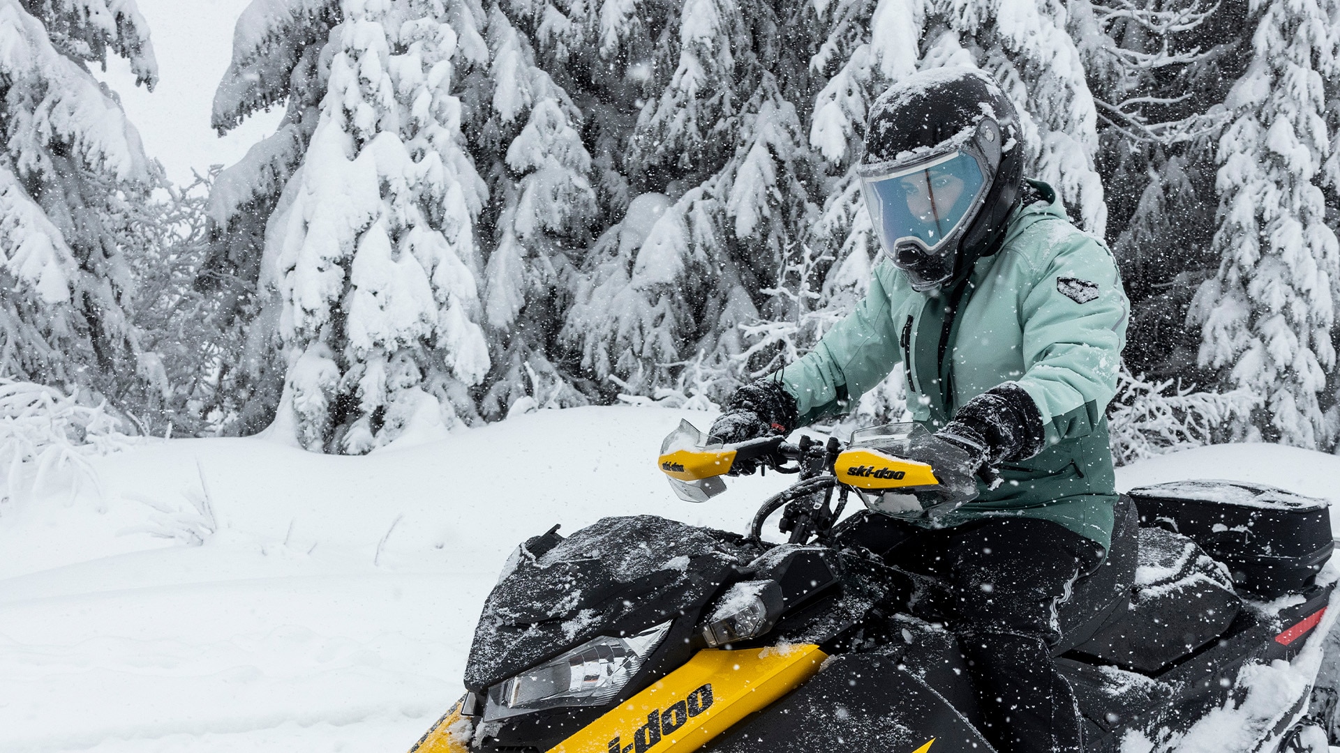 Women riding a Ski-Doo snowmobile 