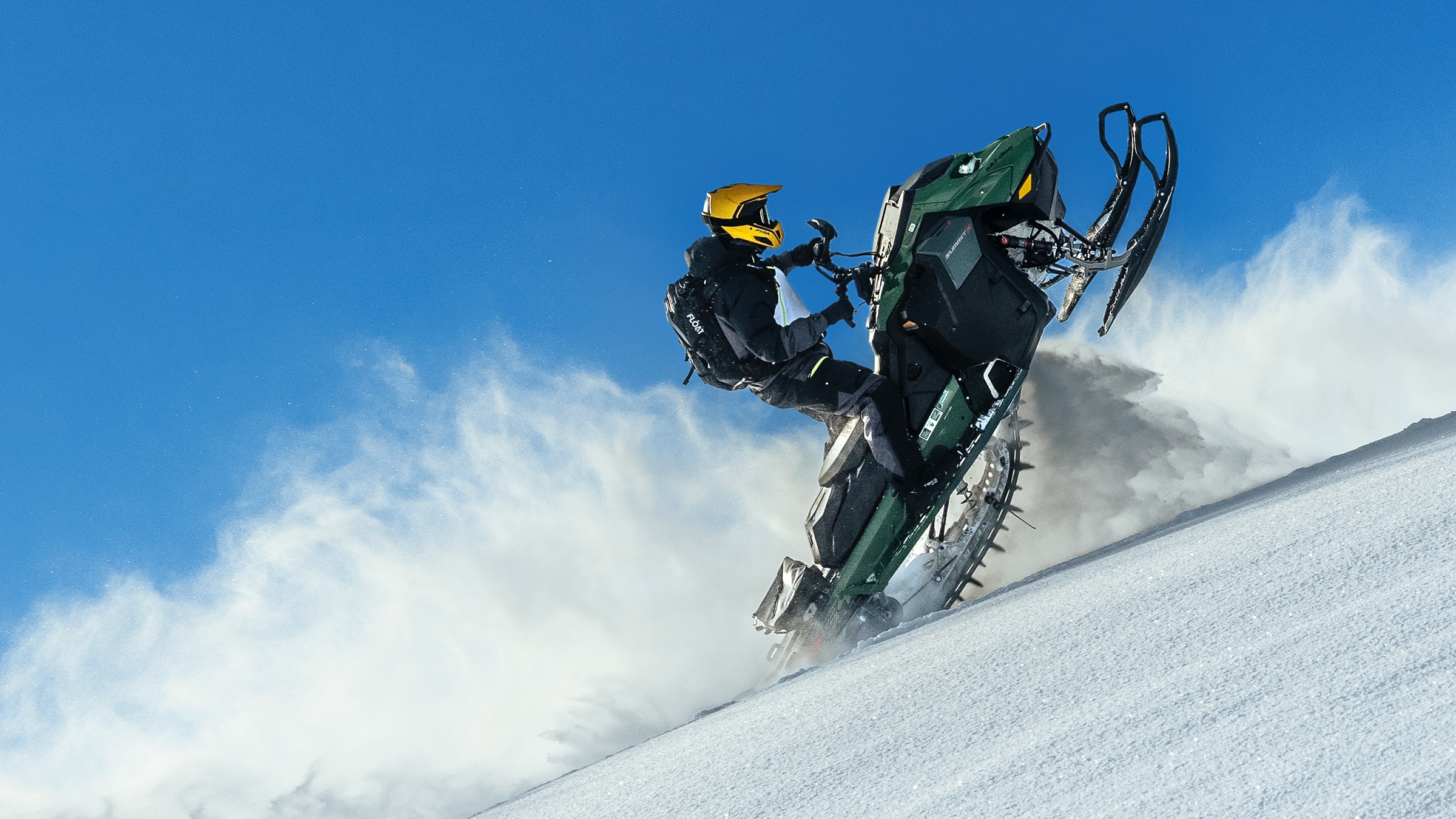 Ski-Doo Summit med Expert-paket accelererar uppför en backe med skidorna i luften