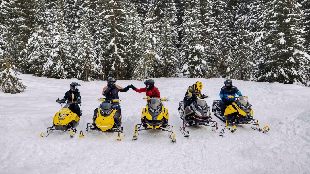 Grupp Ski-Doo-förare på snöskoterled