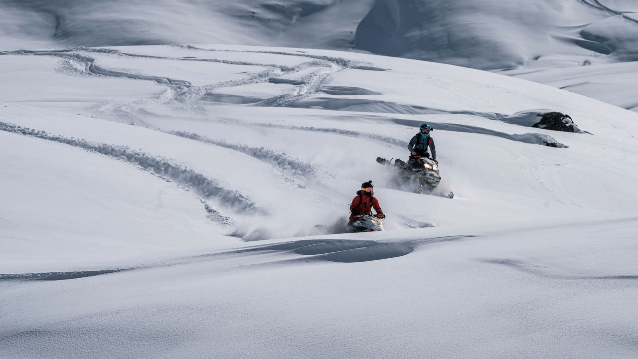 Two women riding their Ski-Doo in deep snow