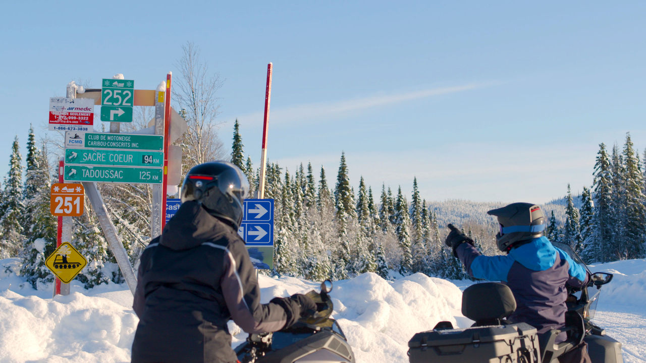 Two riders in a snowmobile Trail