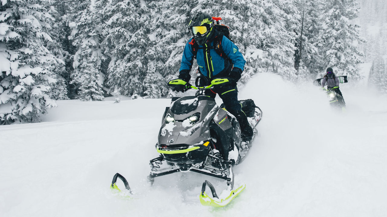 Two riders on their Ski-Doo sleds in deep snow