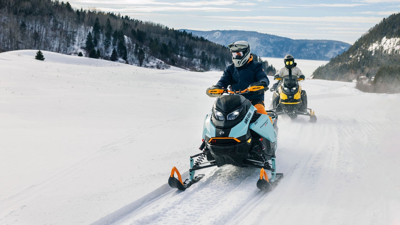 Deux motoneigistes sur des Ski-Doo Backcountry en sentier