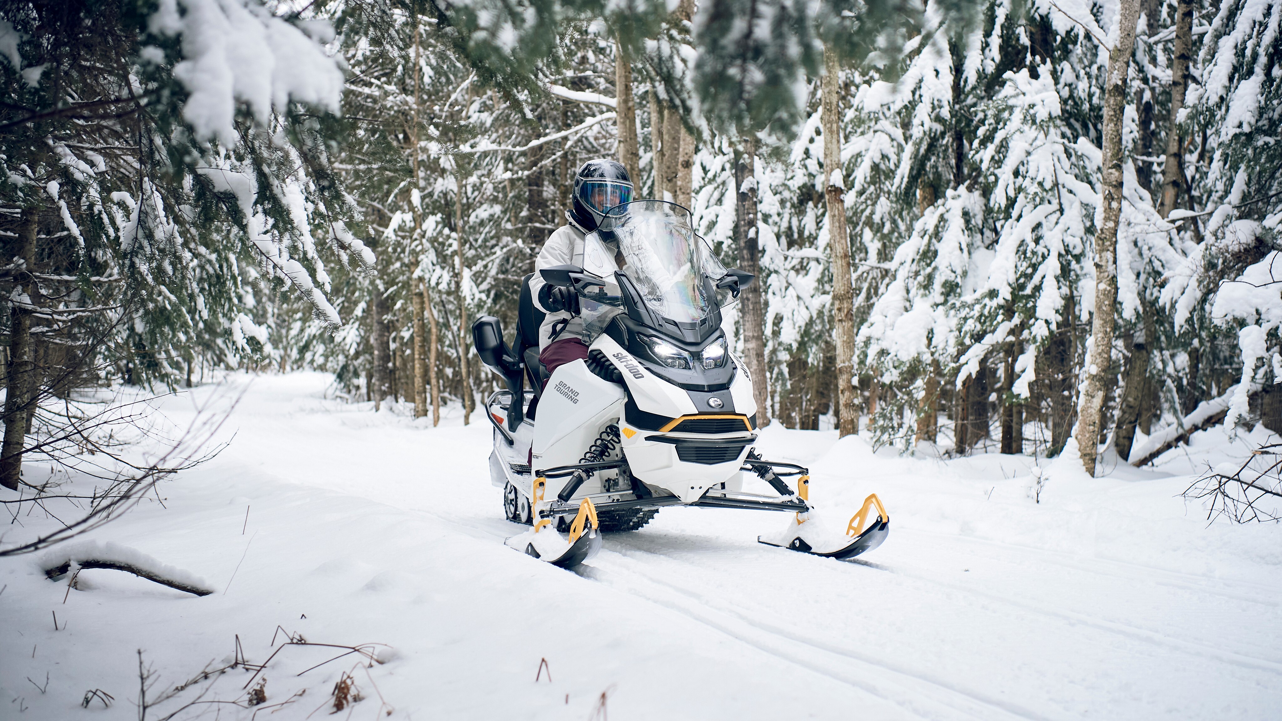 Woman snowmobiling in trail with the 2024 Grand Touring Electric