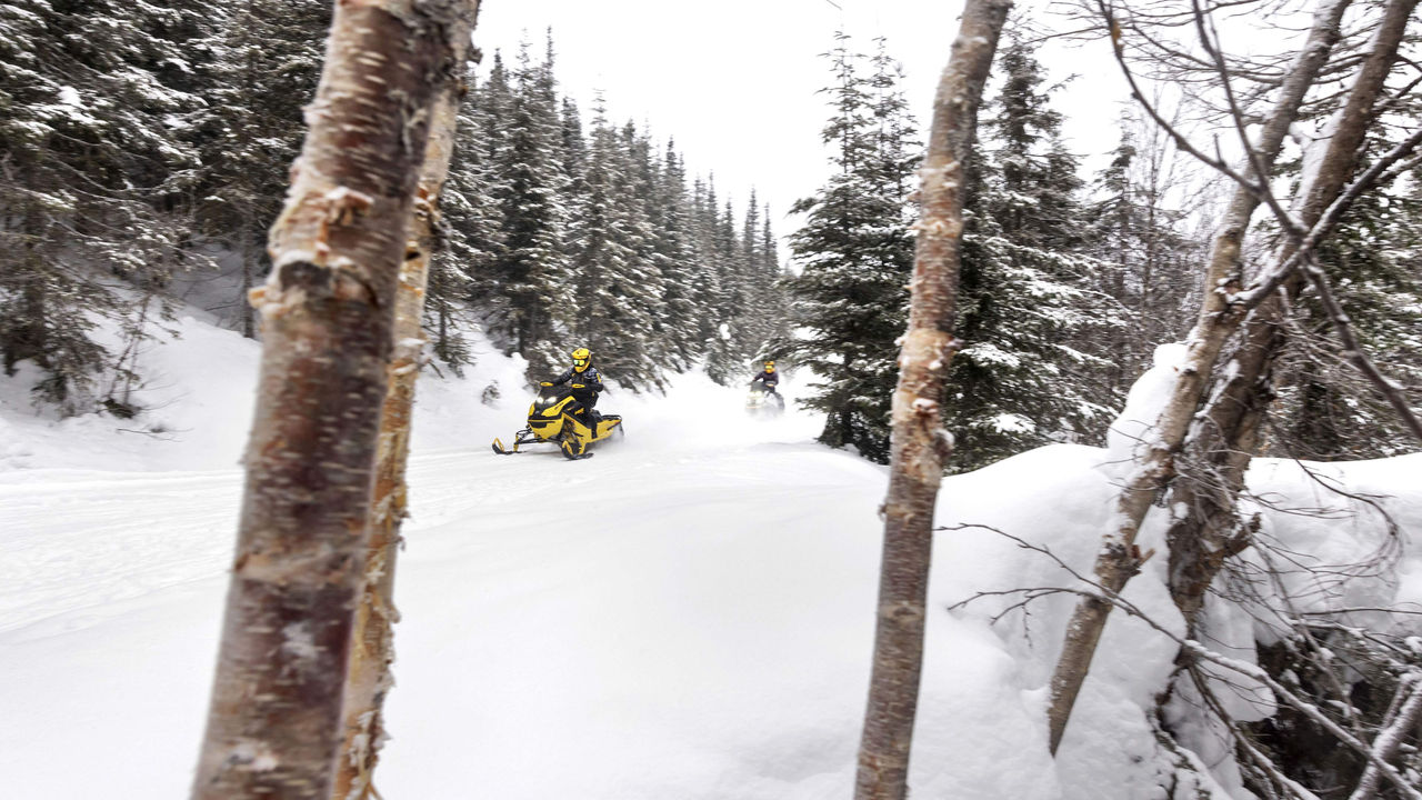 Two riders in a snowmobile trail with their Ski-Doo