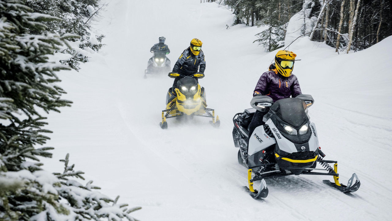 Trois motoneigistes Ski-Doo en sentier