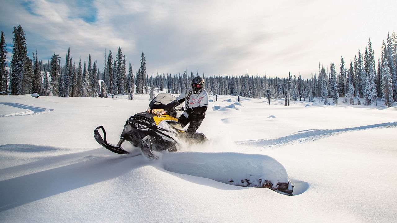 A man riding a tundra in deep snow