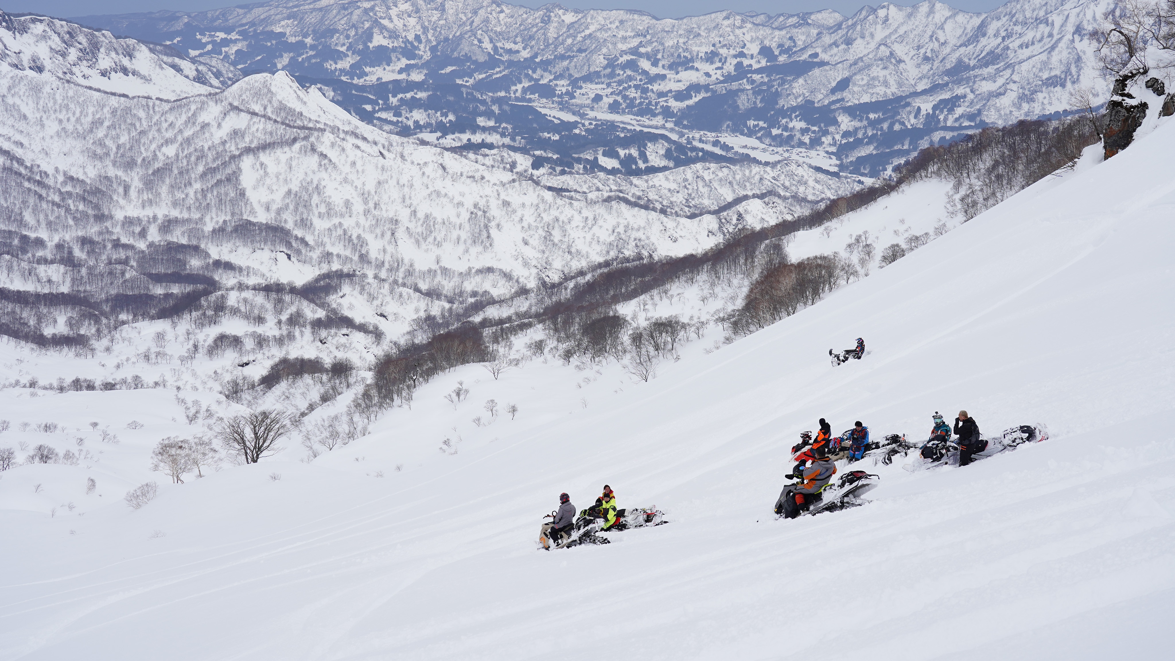 Un groupe de motoneigistes au Pays du Soleil Levant descendant la montagne à bord de leur motoneige Ski-Doo.