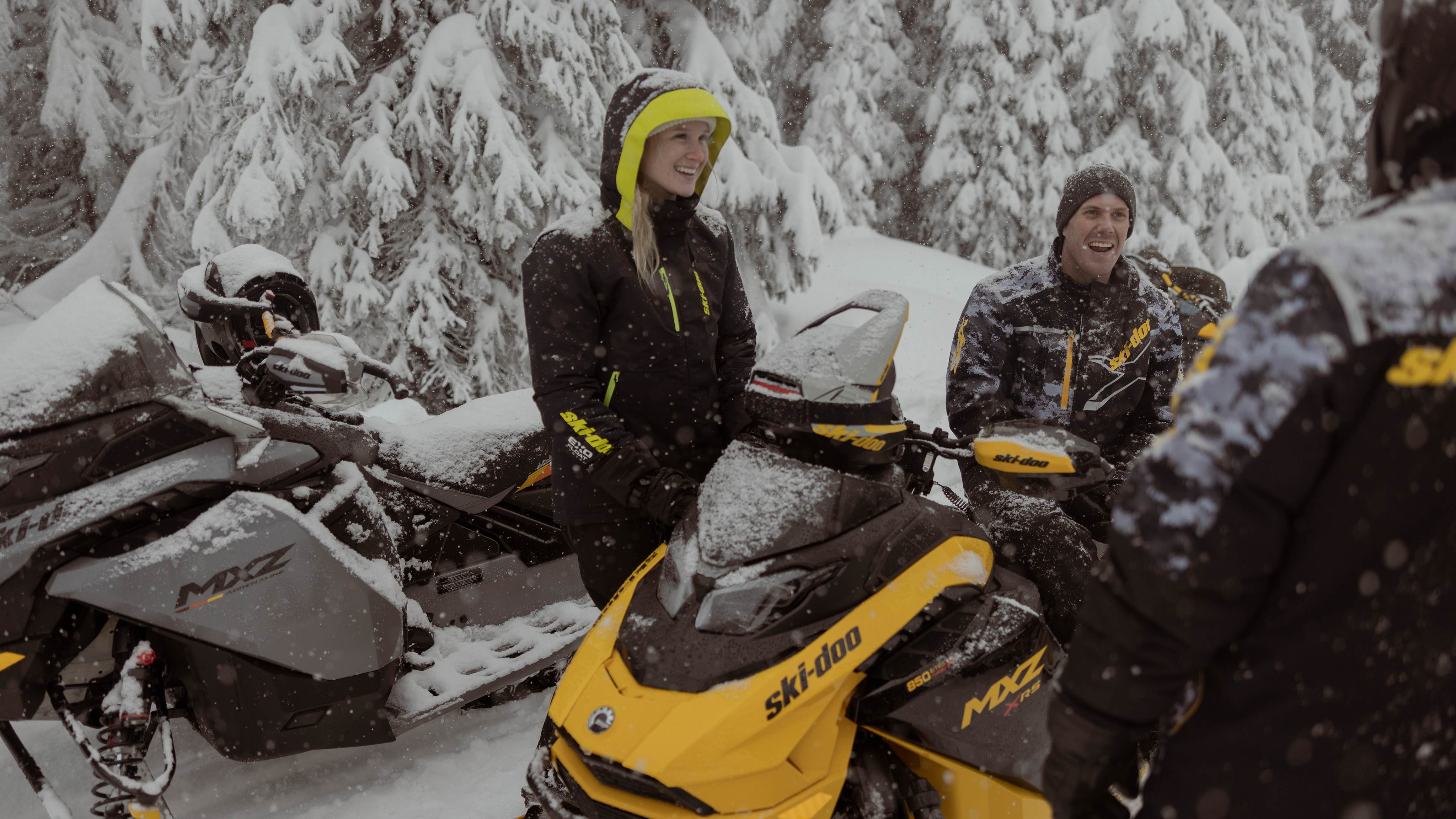 Two people riding a 2025 Ski-Doo Trail snowmobile