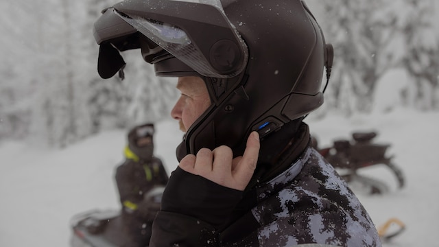 Man using the Vibe communication system on a snowmobile helmet