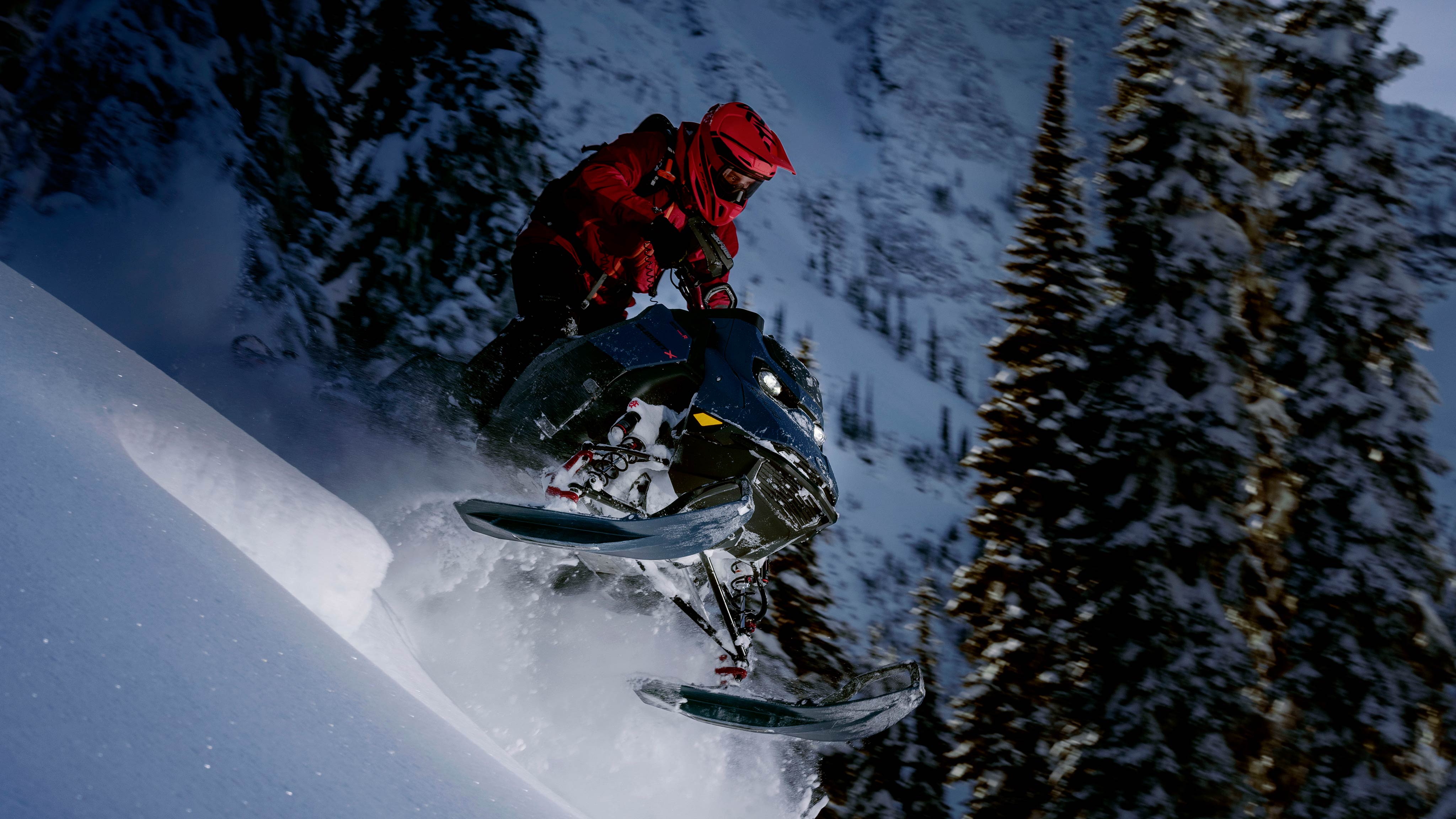Rider going down a mountain on a 2025 Ski-Doo Summit deep snow snowmobile