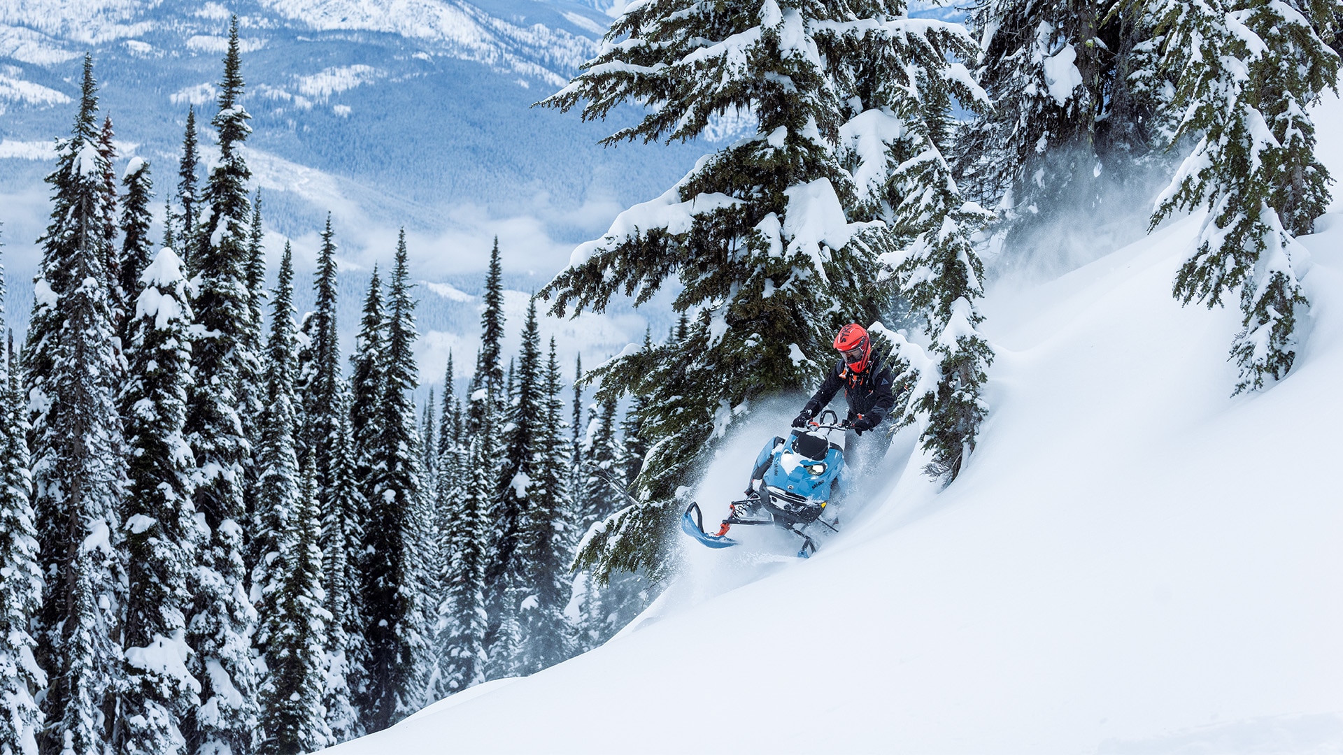 Snowmobiler riding a 2026 Ski-Doo Freeride snowmobile through the deep snow of a mountain.