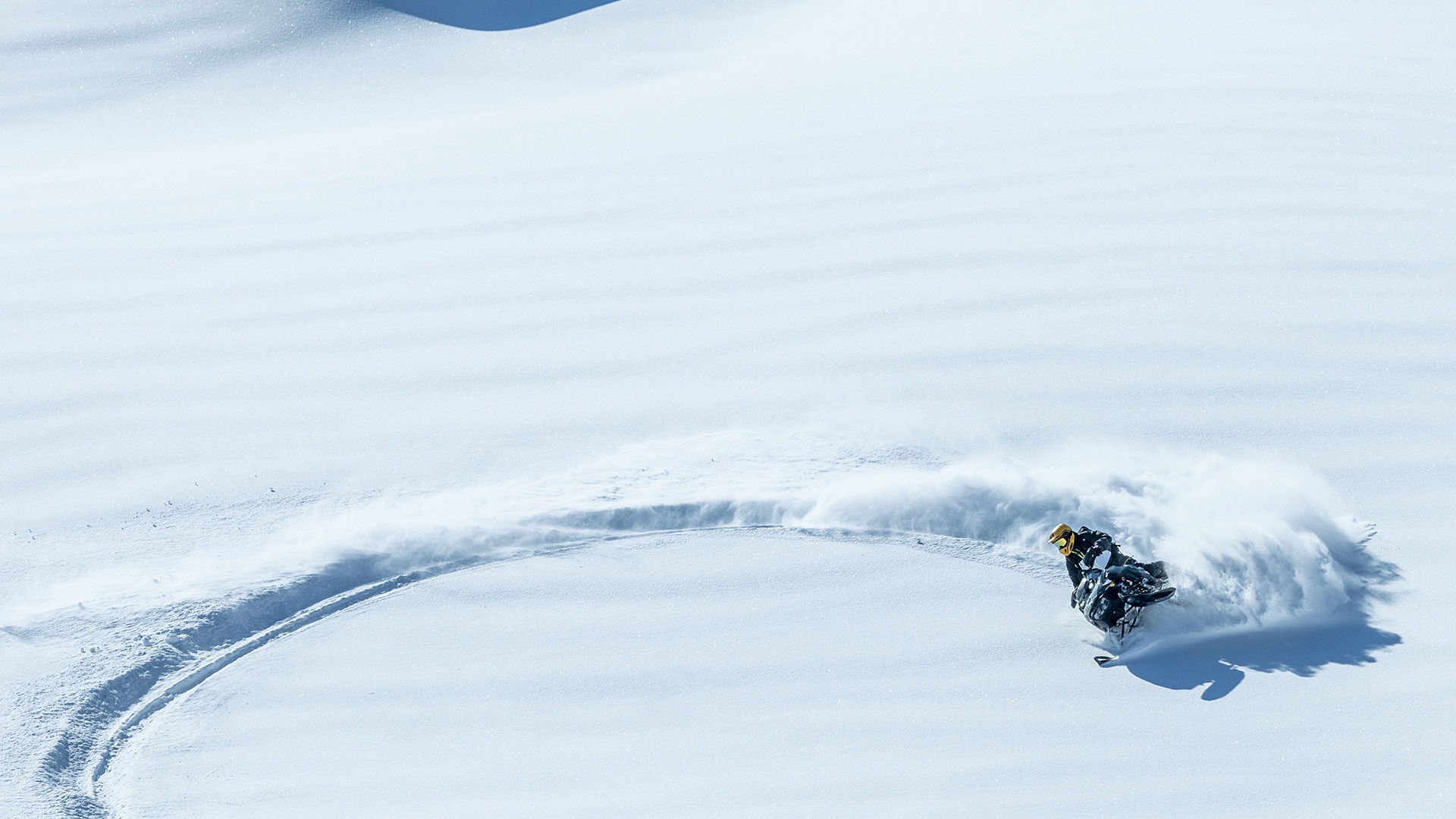 Snowmobile rider turning in deep snow with a 2026 Ski-Doo Summit