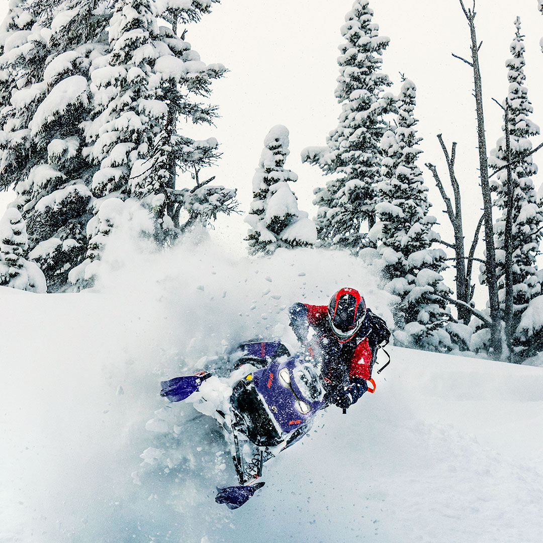Rider speeding down a snowy mountain on a Ski-Doo snowmobile
