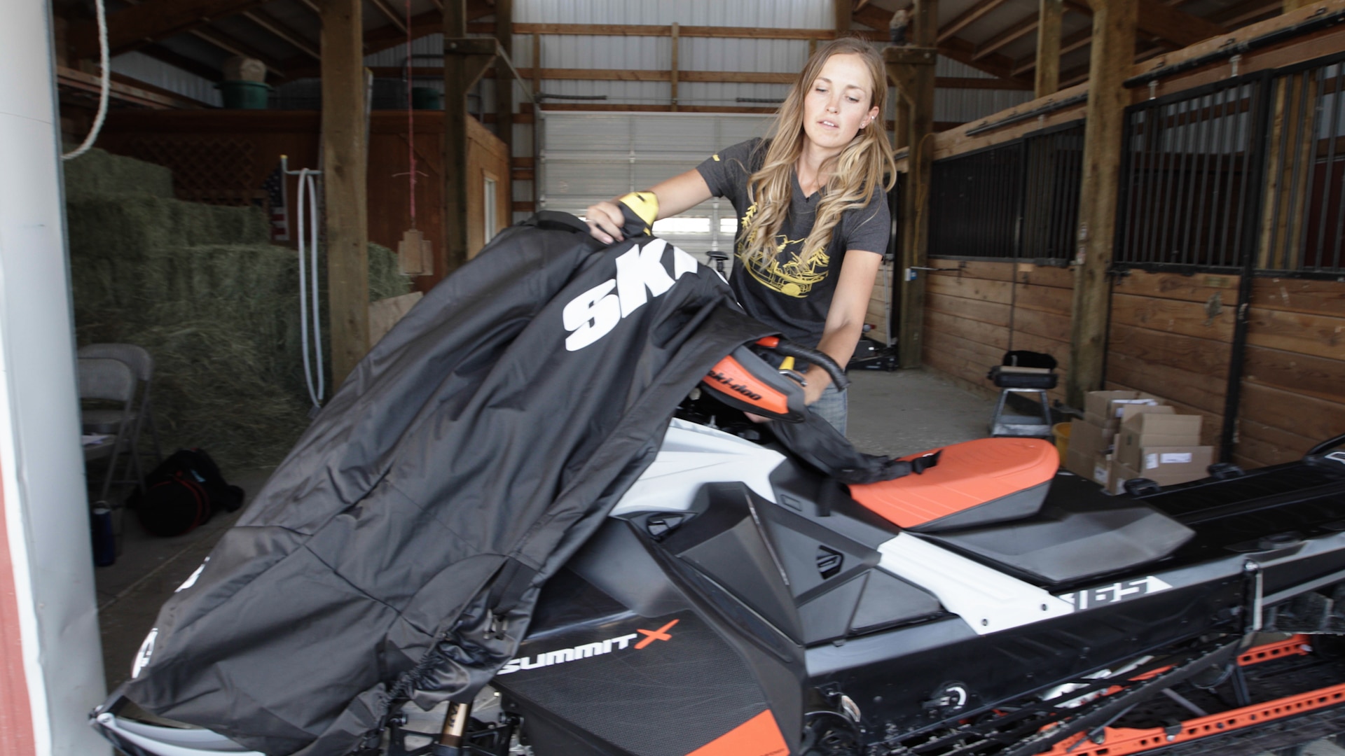 Stefanie Dean peittää Ski-Doo-moottorikelkkansa kesäsäilytystä varten