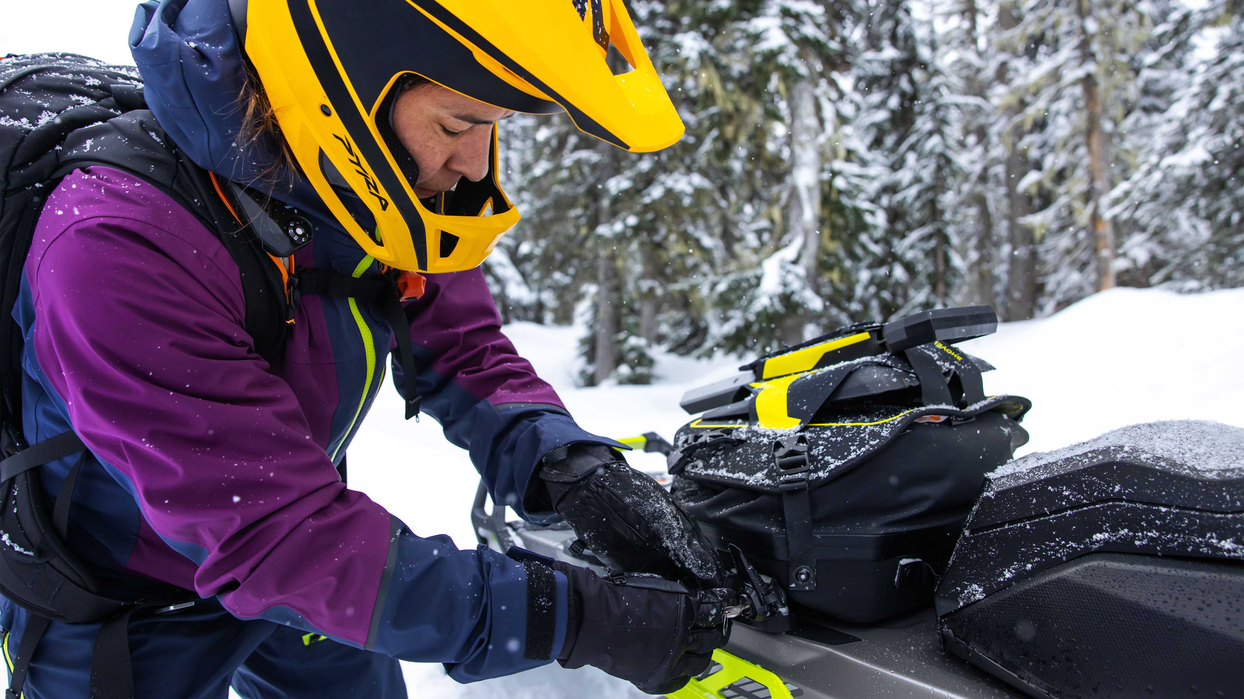 Woman using LinQ Cargo accessories on her snowmobile