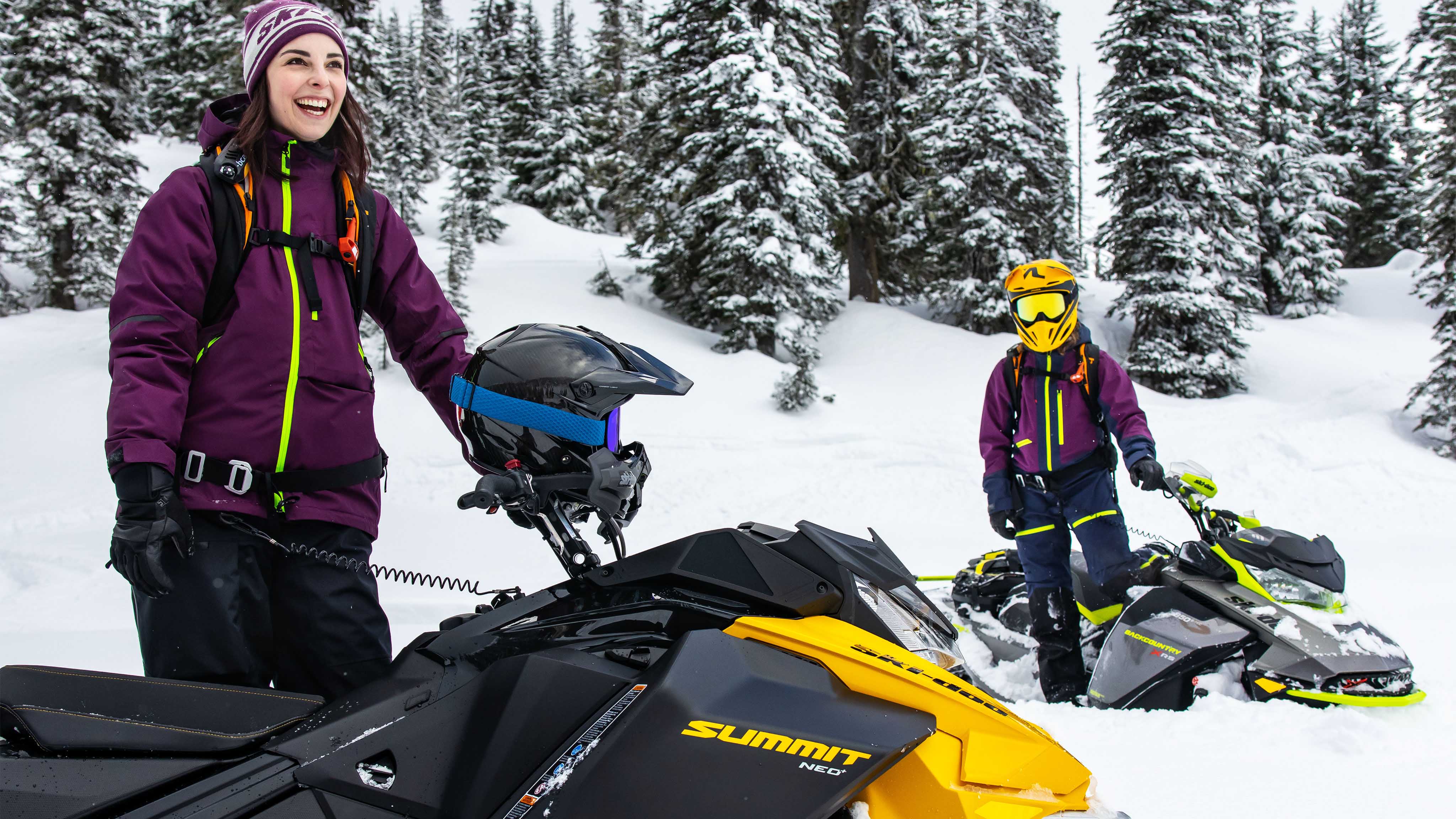 Two women standing on their Ski-Doo sleds