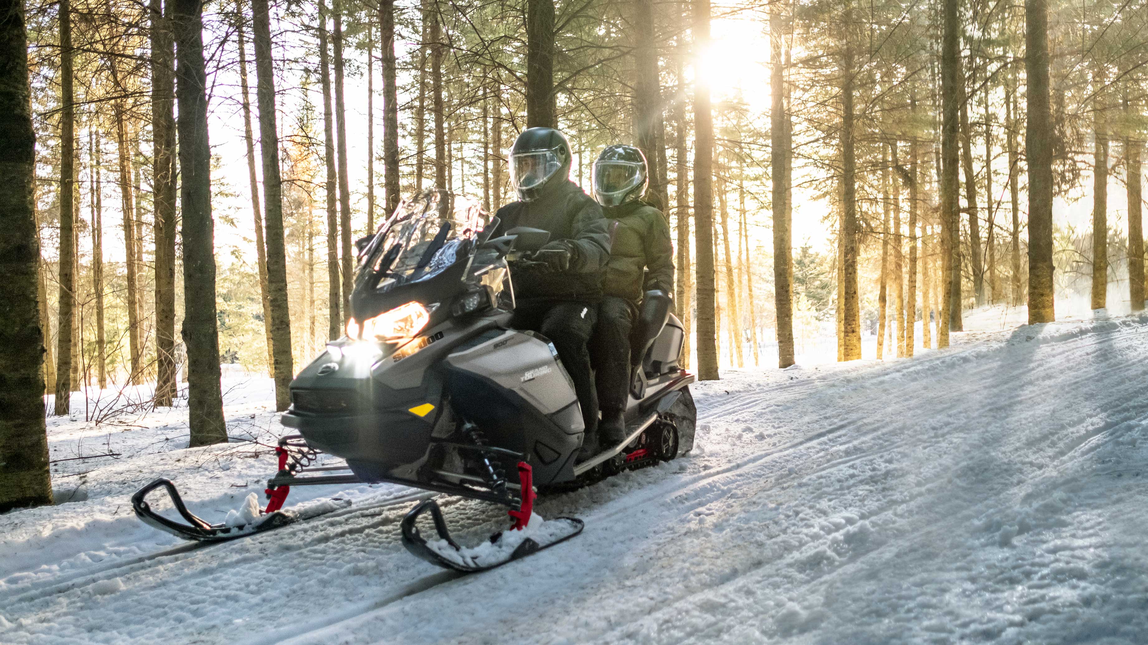 Couple riding Ski-Doo Grand Touring snowmobile
