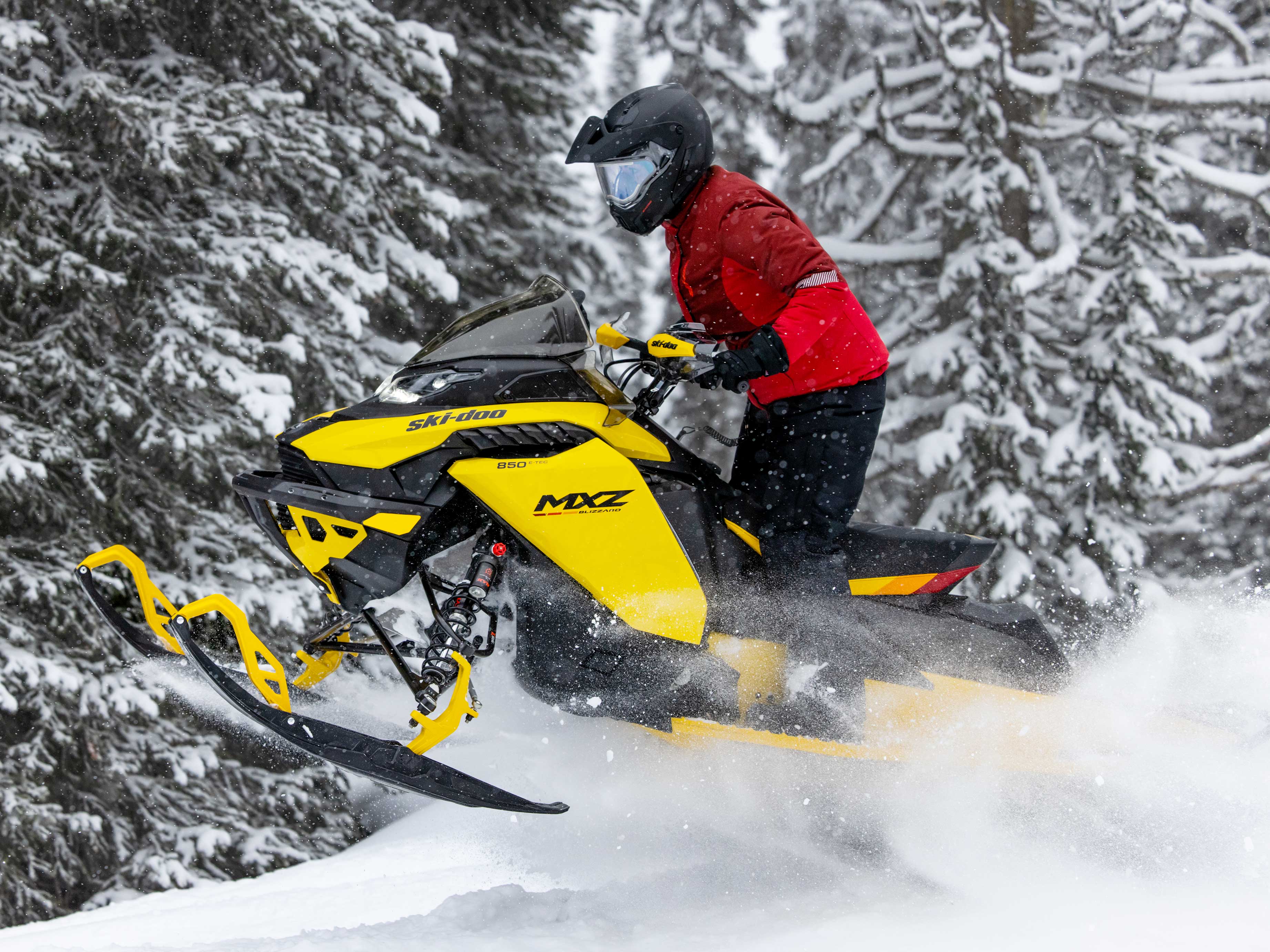 Woman on a MXZ Blizzard making a jump in trail