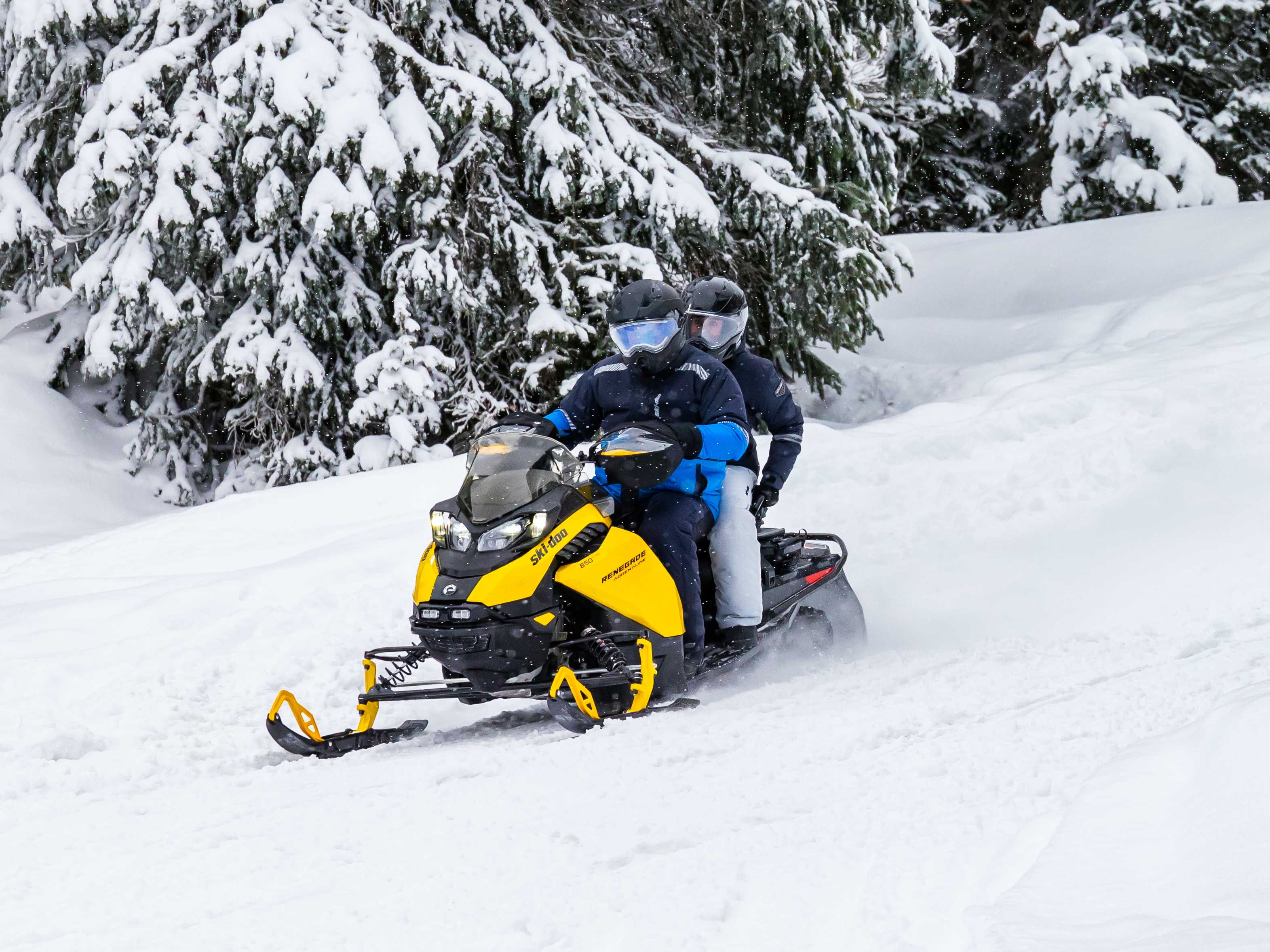 Ski-Doo Snowmobile with passenger on a trail