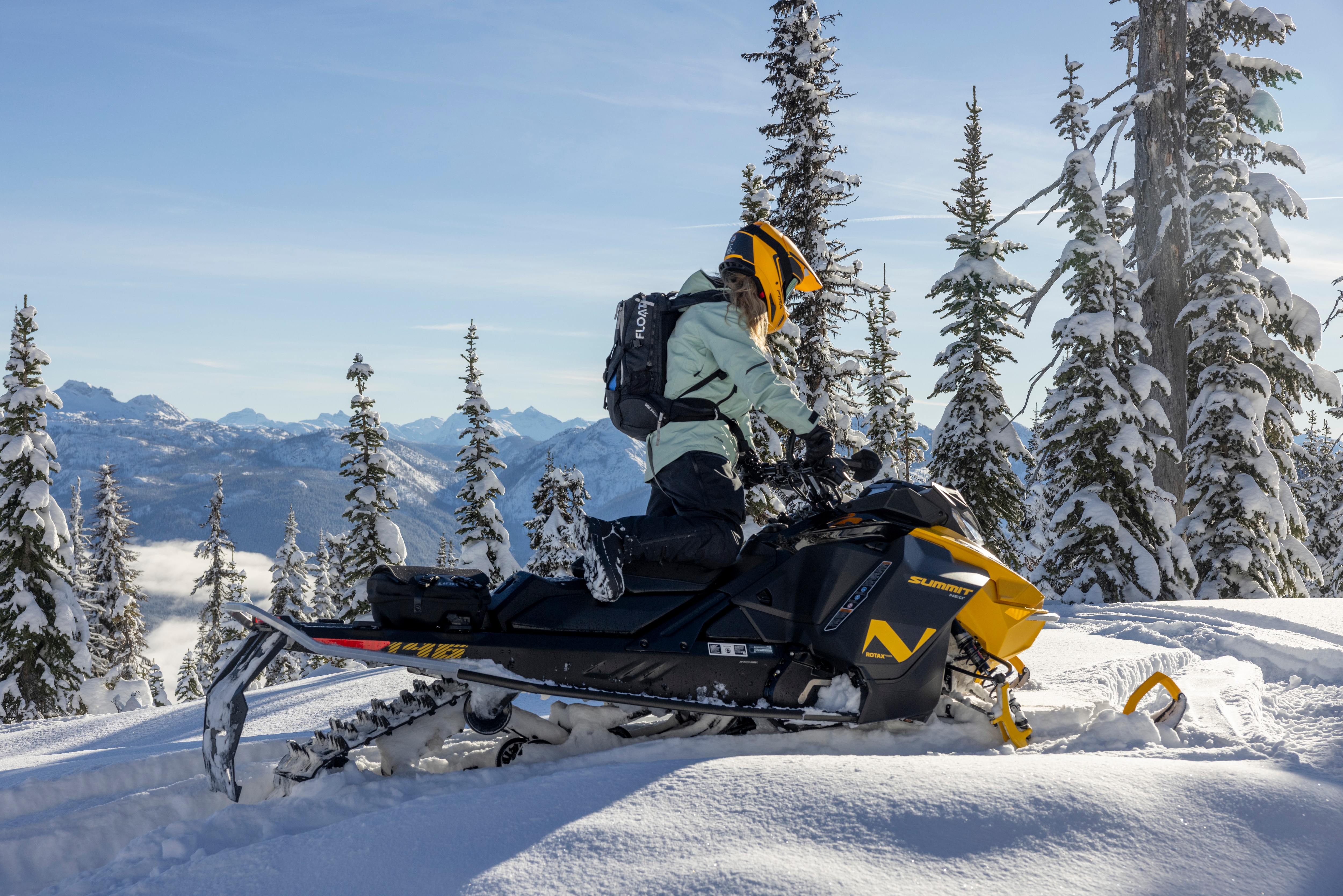 Rider at the top of the mountain on a Ski-Doo Summit snowmobile.