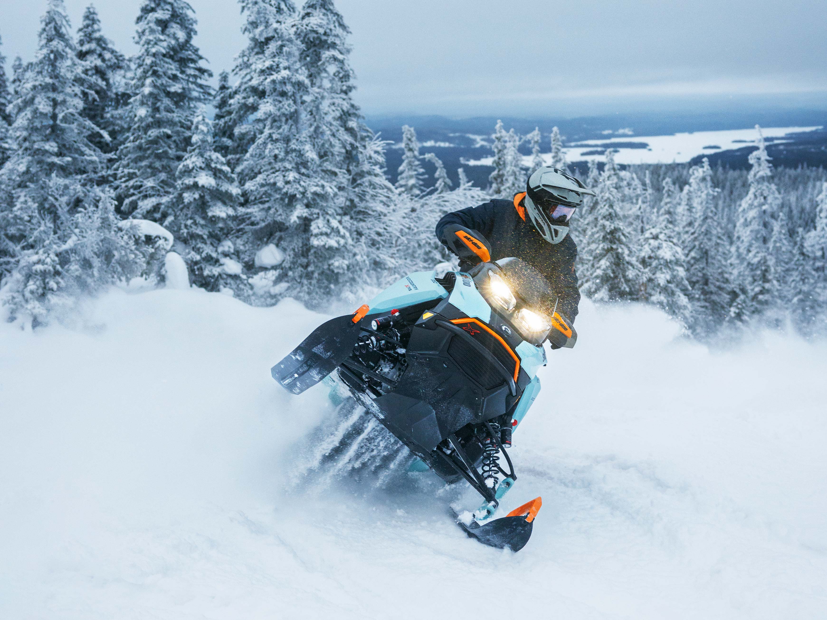 A person riding a Ski-Doo Crossover snowmobile on a mountain.