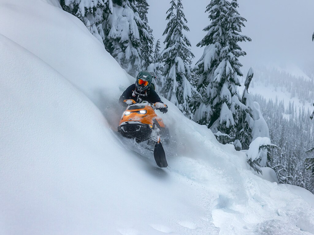 Woman riding a Ski-Doo Summit in deep snow