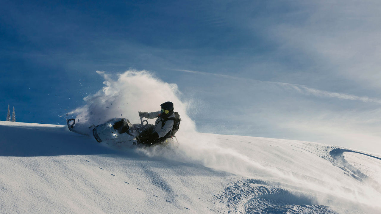 Woman riding a Ski-Doo Summit in deep snow