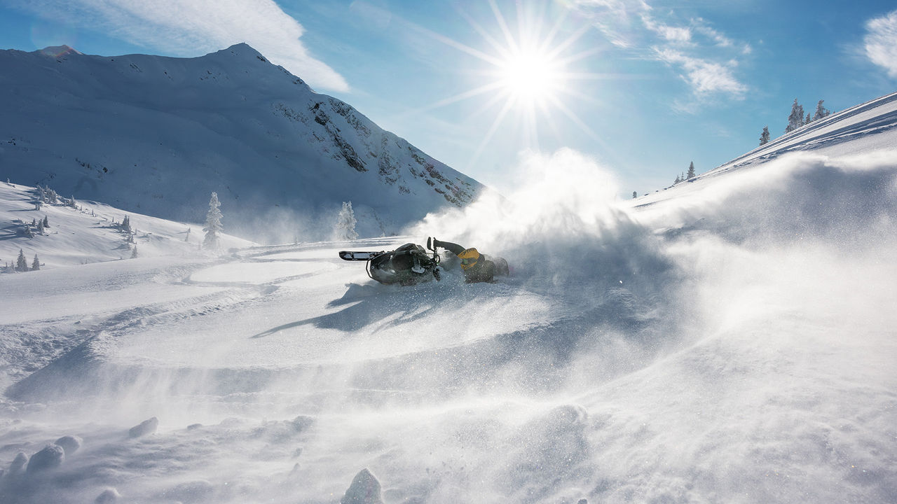 Motoneigiste qui performe une cascade dans la neige profonde sur un Ski-Doo Summit 2026 Motoneigiste qui performe une cascade dans la neige profonde sur un Ski-Doo Summit 2026