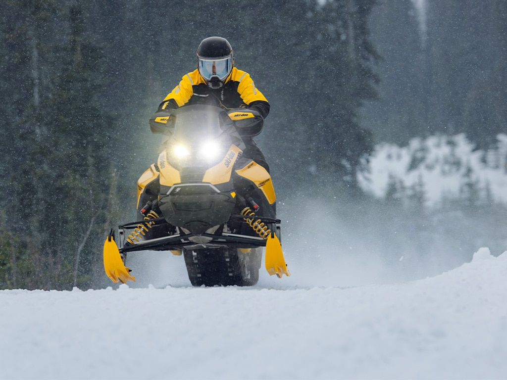 To Ski-Doo 2026 snøscootere klatrer opp en bratt bakke